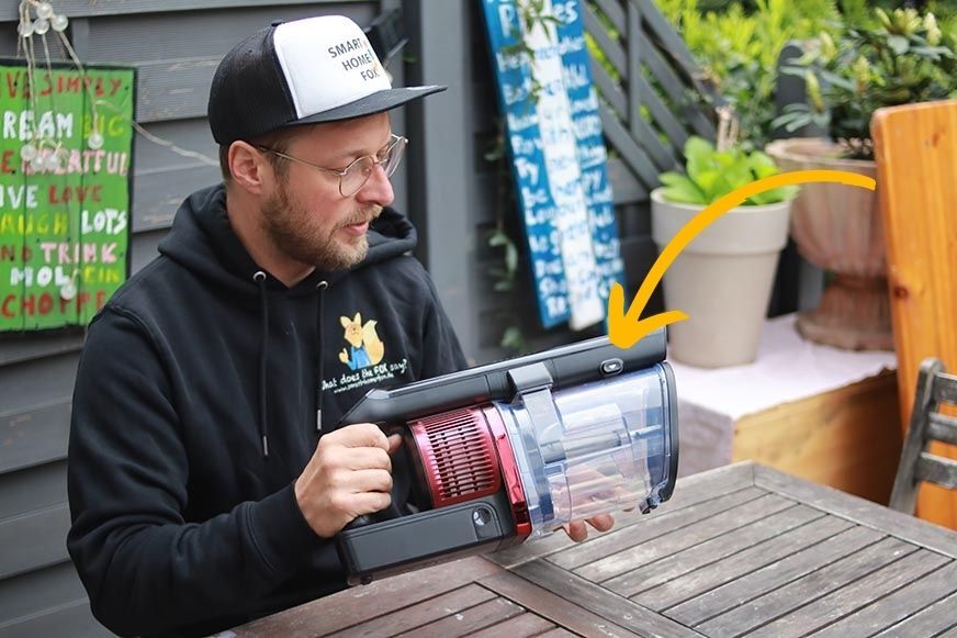 You can see the button for opening the dirt bin. 